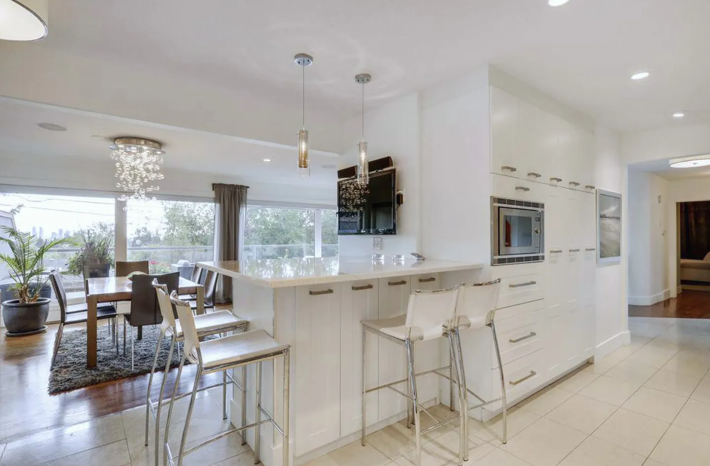 Upper Scarboro kitchen with a white island, pendant lighting and garden-facing dining area