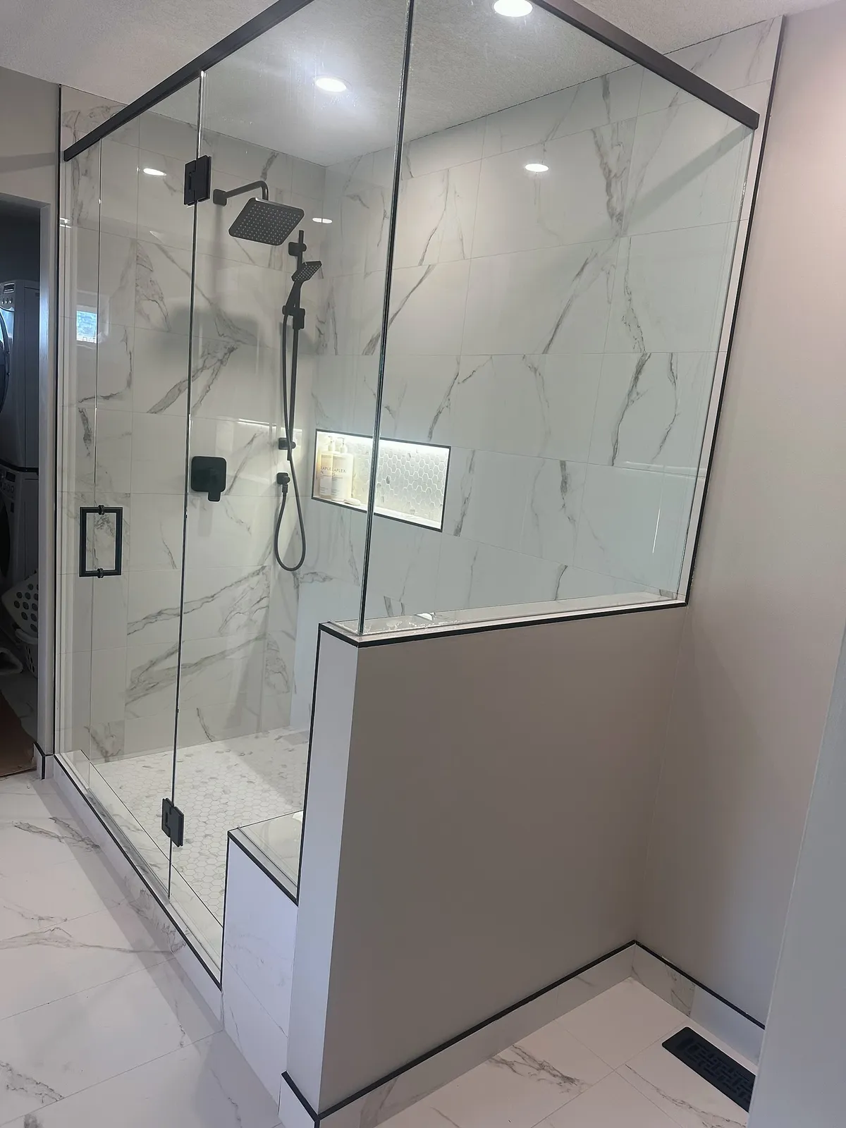 McKenzie Towne ensuite with marble-look tile and a glass shower enclosure