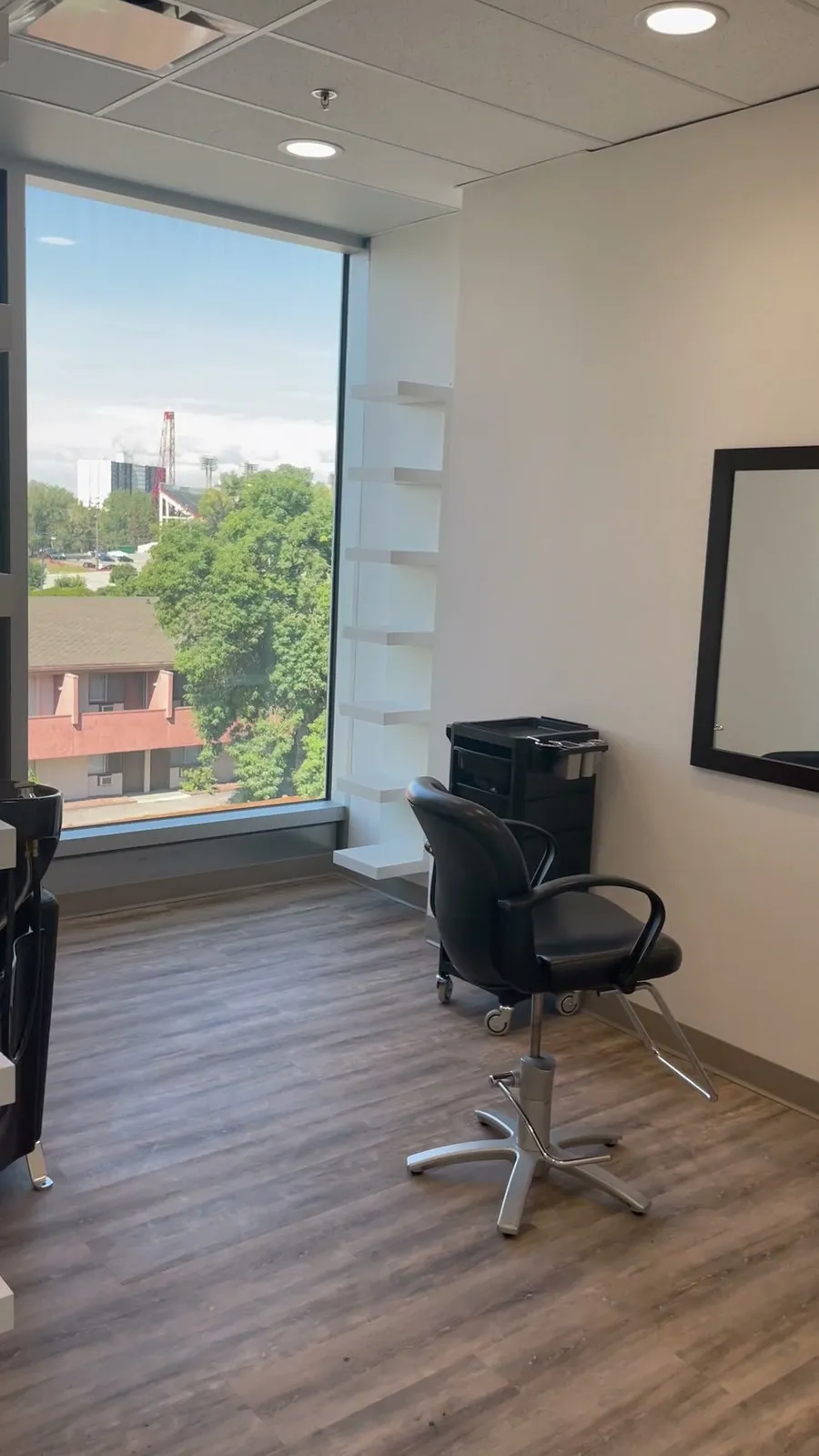 Finished Social Beauty Studios salon with styling chair, mirror, storage and large window