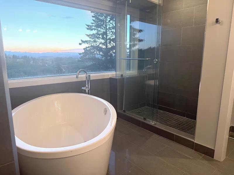 Freestanding tub and glass shower overlooking the landscape at Artists View