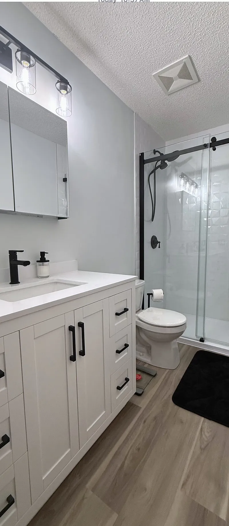 White vanity, mirrored storage and glass shower in Signal Hill
