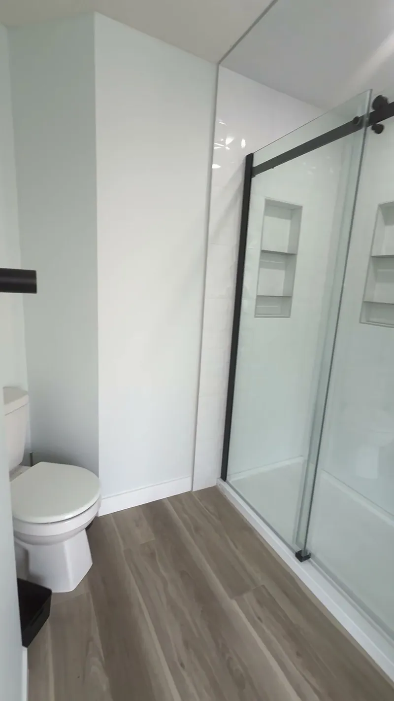 Aspen glass shower with black sliding-door hardware and recessed shelves