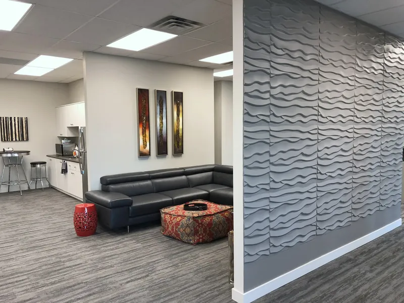 Textured feature wall separating office seating and staff areas