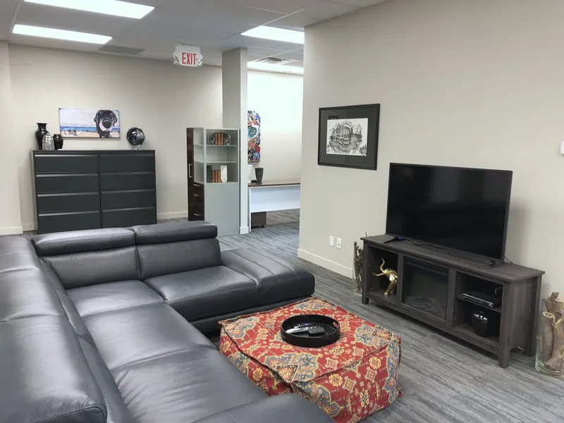 Office lounge with sectional seating and a television