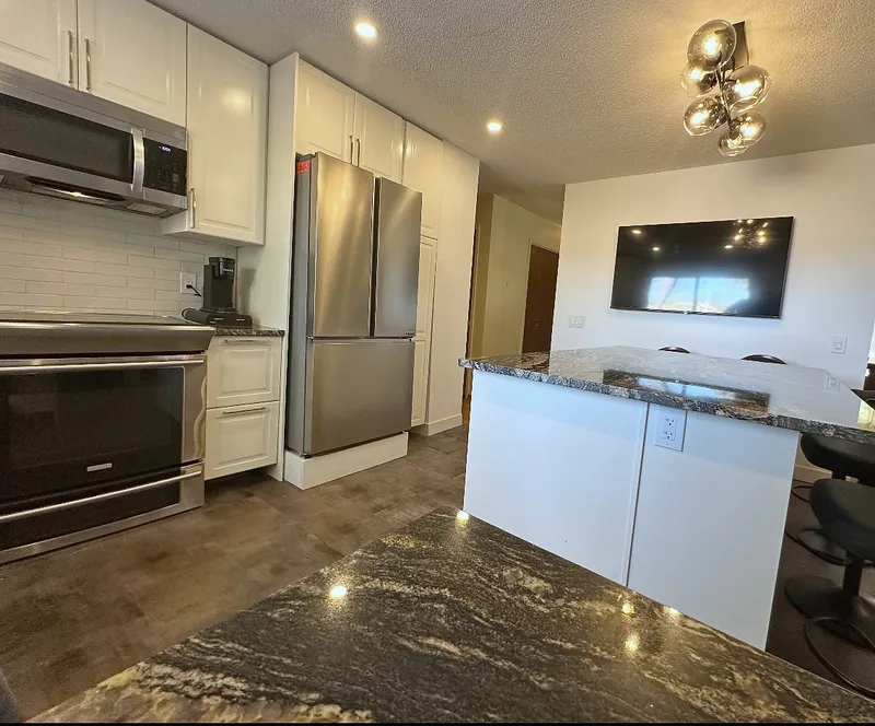 Dark stone worktop and white cabinets beside the Dalhousie kitchen