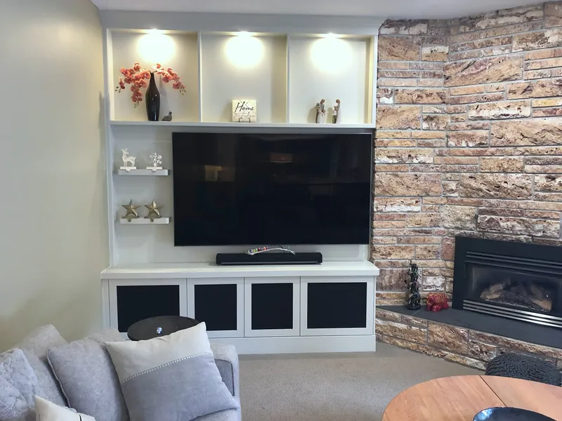 Edgemont living room with stone fireplace and illuminated display cabinetry
