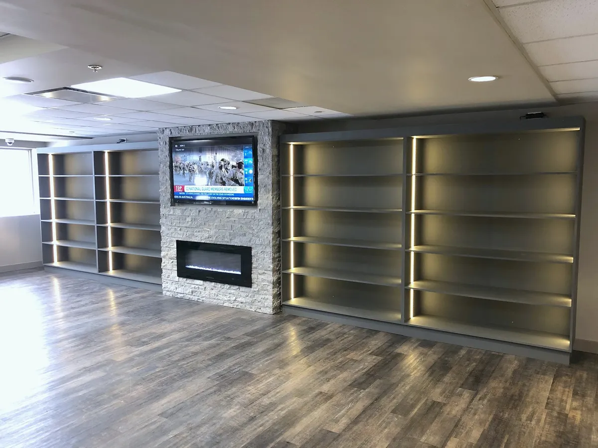 Stone fireplace and illuminated shelving across the Silver Springs members lounge