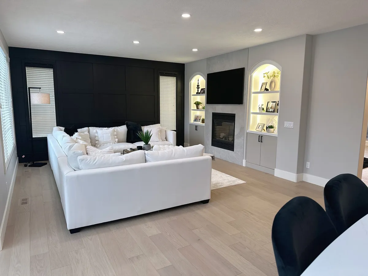 Wentworth living room with white seating, fireplace and illuminated arched shelves