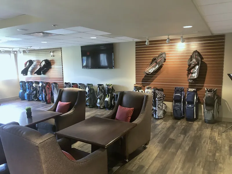 Silver Springs lounge seating beside a wood wall displaying golf equipment