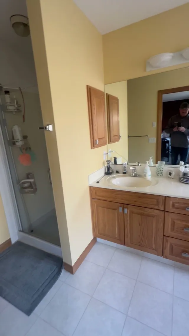 Aspen ensuite before renovation with a wood vanity and older shower