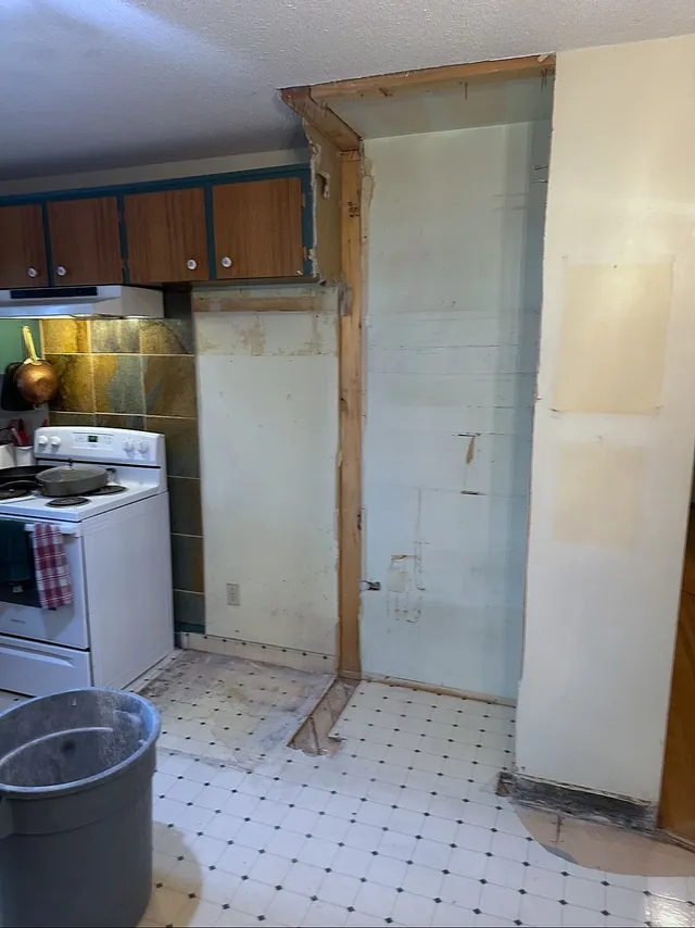 Original wood cabinets and tiled kitchen floor during removal