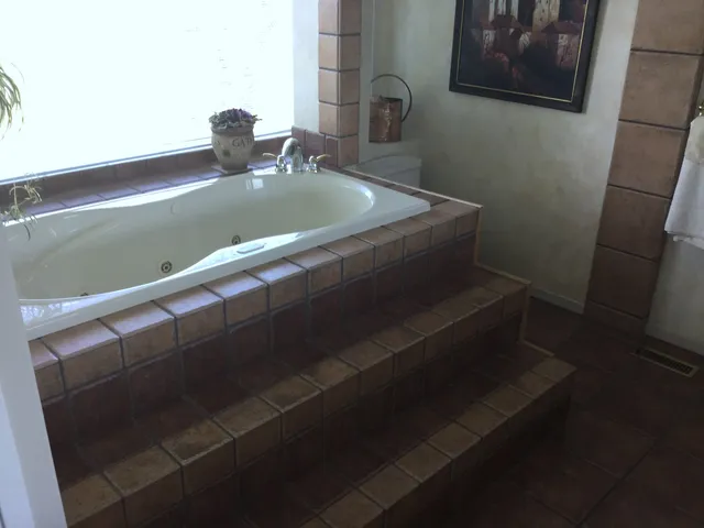 Built-in tub with tiled steps before the Artists View ensuite renovation
