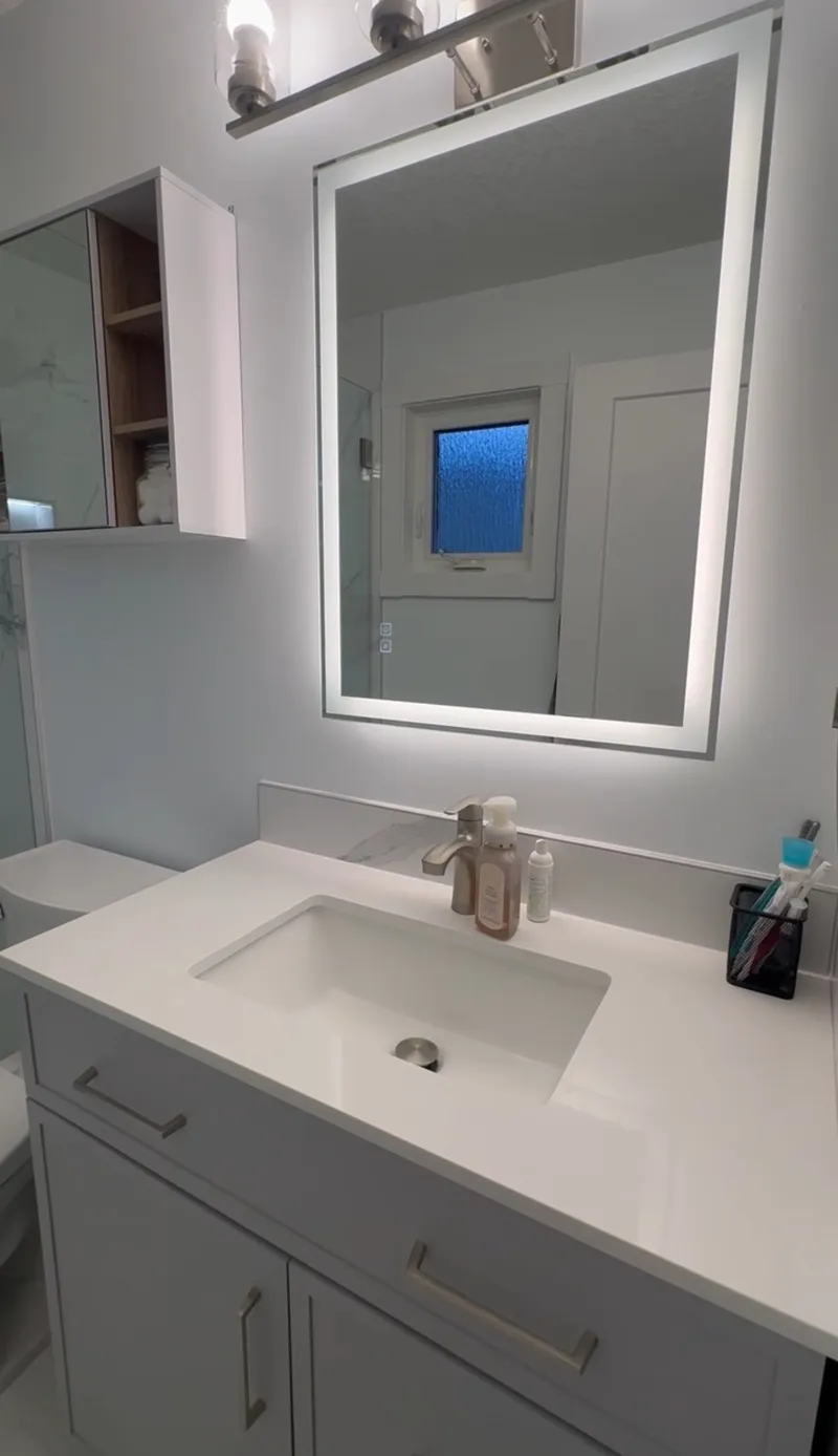 Bathroom vanity with illuminated mirrored storage