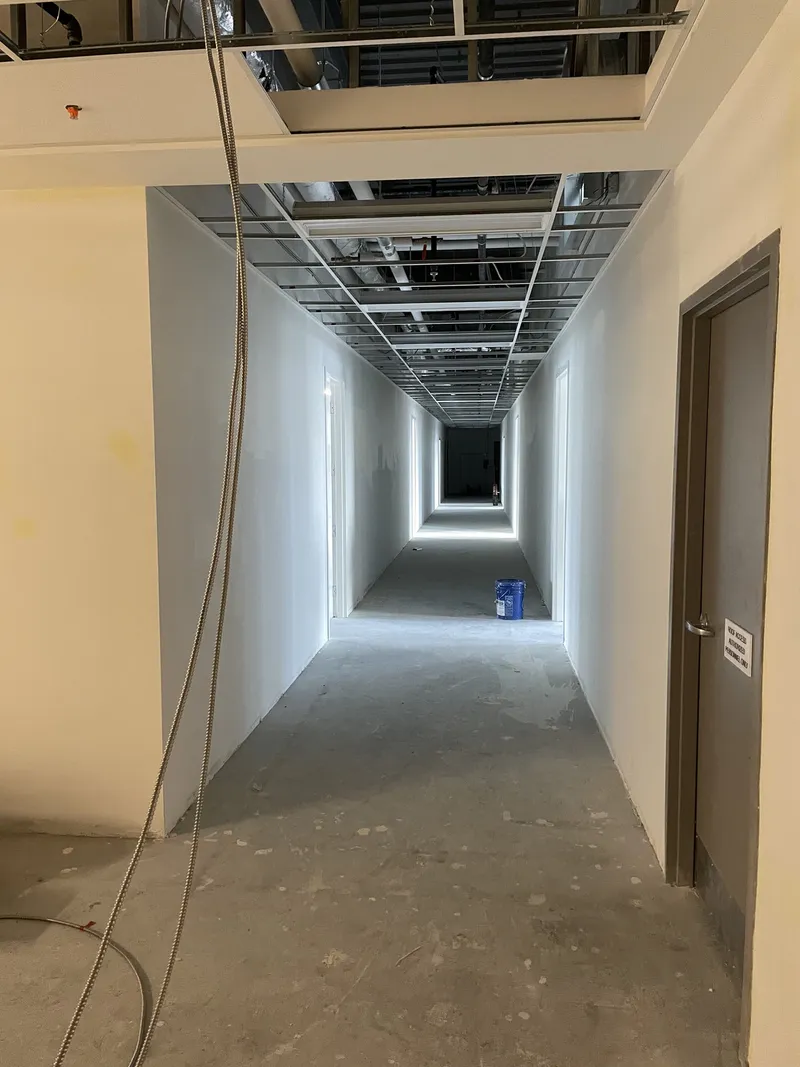 Social Beauty Studios corridor during construction with exposed ceiling grid