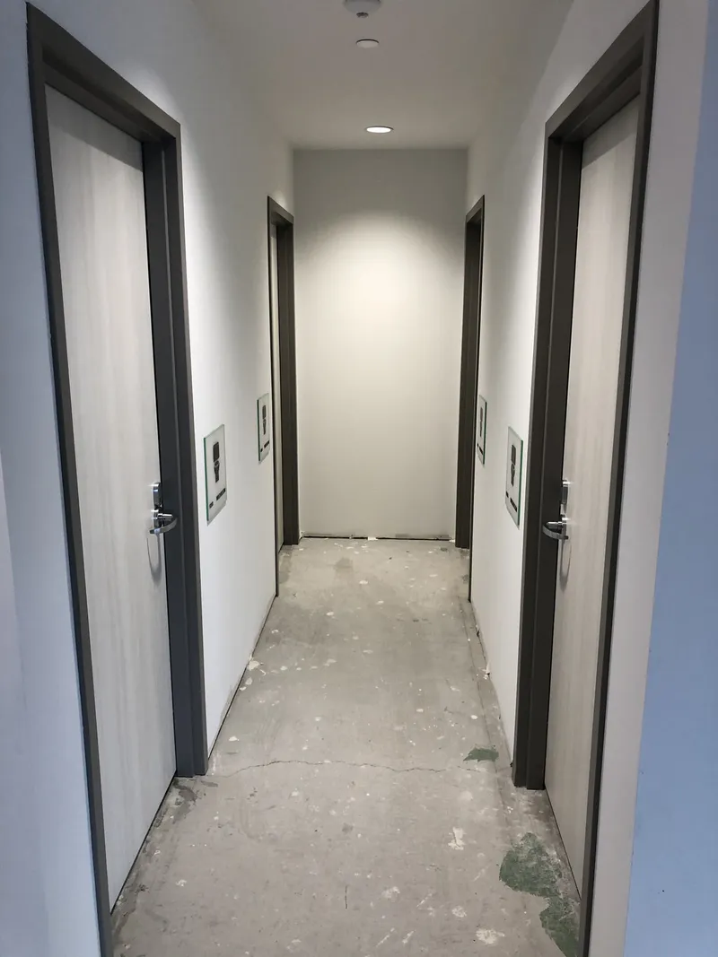 Shared washroom corridor at Social Beauty Studios before floor finishing