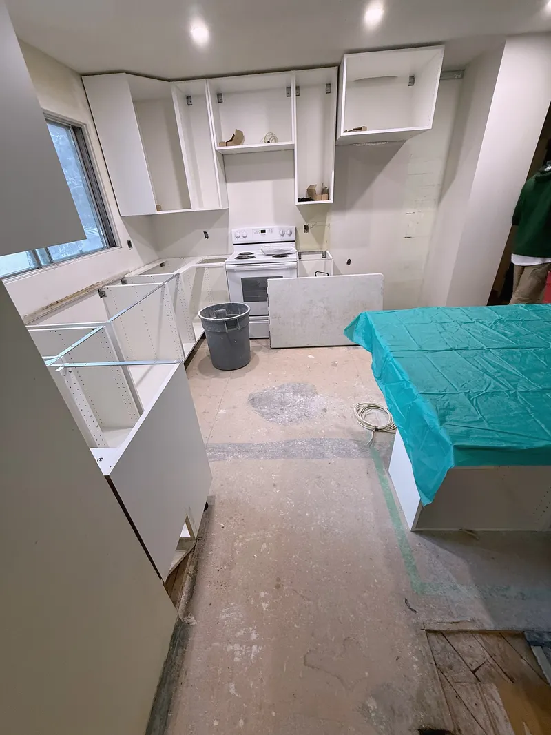 Covered kitchen island and unfinished cabinetry during installation