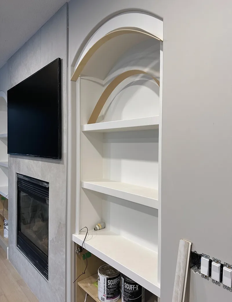 Arched display shelving under construction beside the Wentworth fireplace